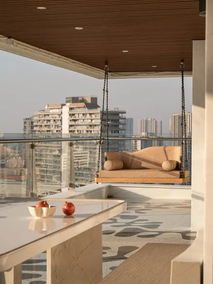 Another view of the terrace, showing the sleek marble table and the reversible swing, a perfect setup for everything from quiet mornings to lively evenings.