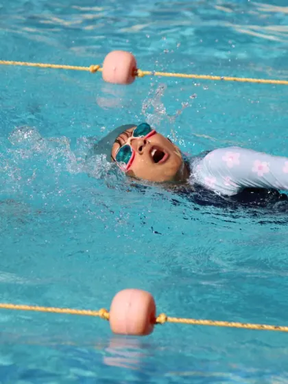 Another angle of backstroke practice, showing the swimmer's head position and arm recovery. Proper form is essential for speed and preventing injury.