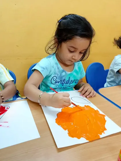 Look at the focus on her face. Painting is a wonderful activity that allows children to explore their creativity, improve concentration, and develop fine motor skills.