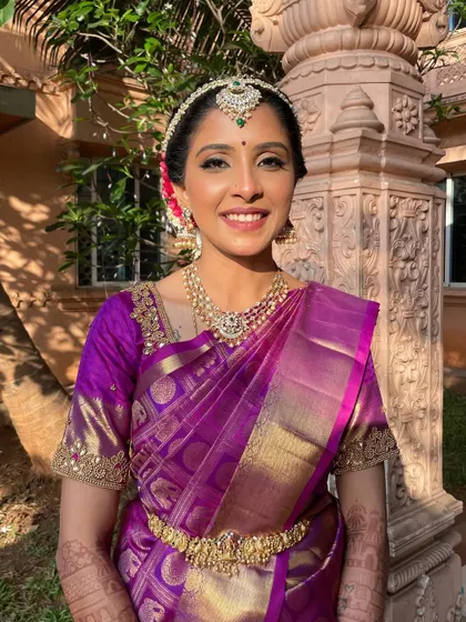 A beautiful portrait of our Muhurtham bride. The makeup is kept classic and luminous, with a focus on highlighting her features to match the grandeur of her purple silk saree.