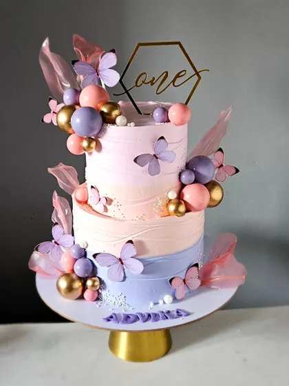 A dreamy, "so pinteresty" butterfly cake in whipped cream. This three-tier cake features a beautiful pastel ombre and is adorned with butterflies and rice paper sails.