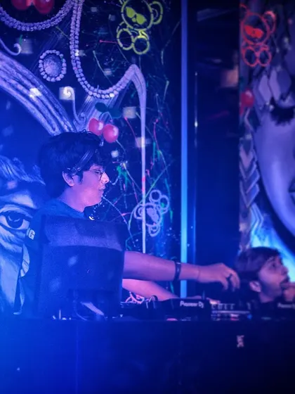 Setting the mood, one track at a time. This photo captures a moment of concentration at Toy Room, surrounded by the club's unique artwork.