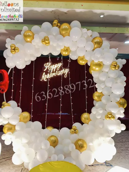 The circular balloon arch for the 25th anniversary, showing the combination of white and gold balloons with fairy light details.