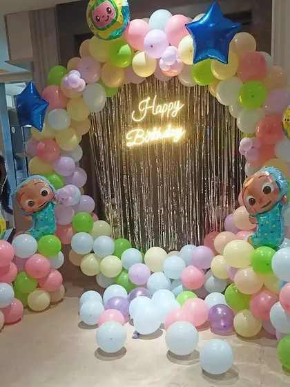 This angle showcases the round shape of the Cocomelon balloon arch and the placement of the character foil balloons.