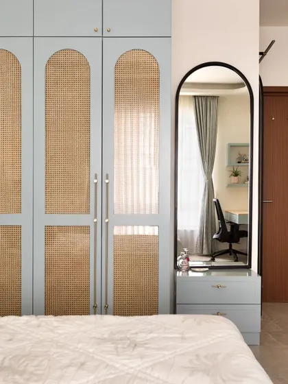 This elegant wardrobe features rattan panels framed in a calming powder blue, accentuated by handmade brass handles. It's a beautiful example of how storage can be a statement piece.