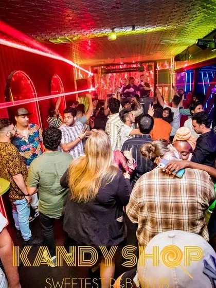 A wide view of the party at Kandy Shop, with colorful lights illuminating a full house. I work to build the energy throughout the night.
