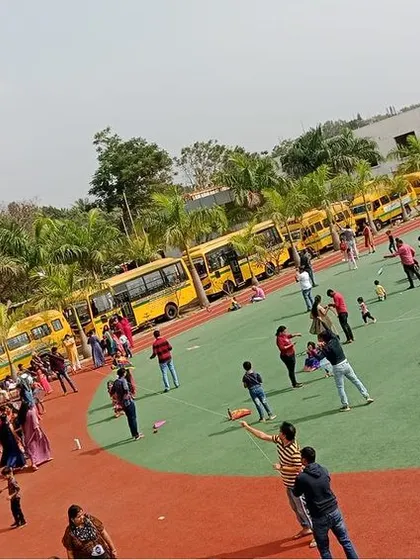 An aerial view of our school ground filled with students and parents flying kites during the Makar Sankranti festival, a celebration of harvest and community.