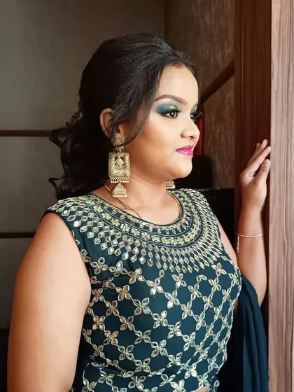 A student looking elegant after a class demonstration where I created this green halo-eye makeup look. It's rewarding to see them feel confident and beautiful.