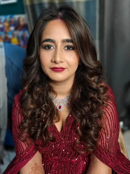The bride looks absolutely radiant. The voluminous curls and glamorous makeup are perfect for a grand reception.