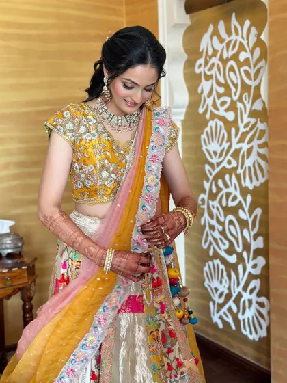 A lovely posed shot of the bride, looking down at the details of her vibrant lehenga.