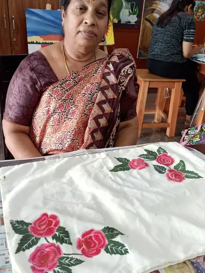 Ms. Sevanjali proudly displays her hand-painted cushion cover from our fabric painting class. Learning to paint on fabric opens up a whole new world of creative possibilities for home decor.