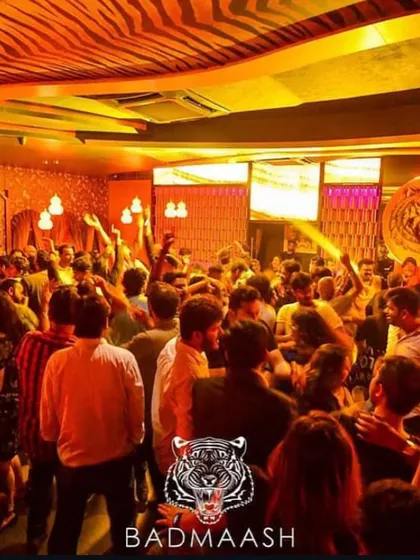 A snapshot of a typical high-energy Bollywood night at Badmaash. The dance floor is completely packed, with everyone's hands in the air, lost in the music.