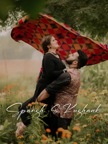 A fun and vibrant pre-wedding photo with a Punjabi touch, featuring a colorful phulkari dupatta in a field of flowers.