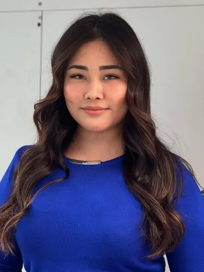 A happy client with her new warm brown brunette hair. The color is natural, rich, and full of shine.