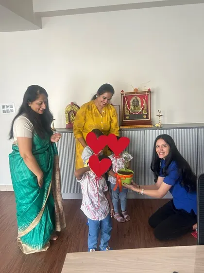 Receiving a plant from two young students at Cambridge Juniors. These warm, personal interactions are what make my school visits so special.