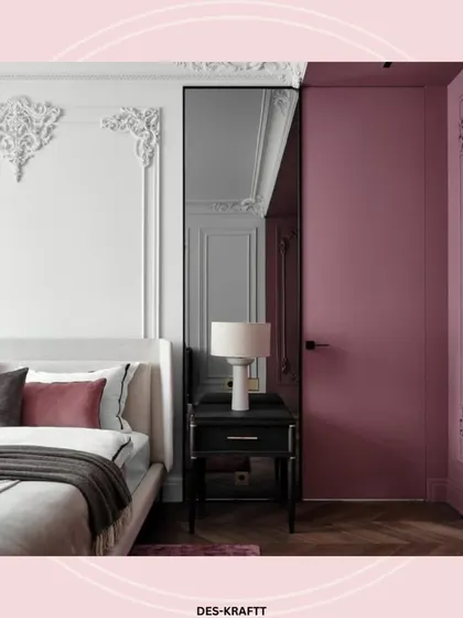 This detail shot shows how a mirrored panel and a solid mauve-colored door create a dynamic and unexpected design feature next to the bed.