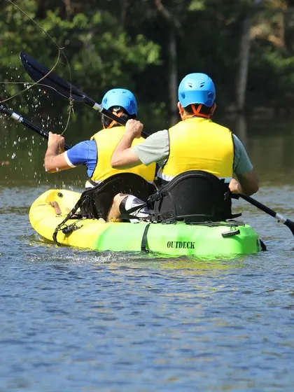 A pair of kayakers navigate the calm river. We provide all the necessary safety equipment, including life vests and helmets, for a worry-free experience.
