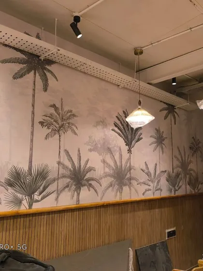 A grayscale palm tree mural in a commercial space, likely a cafe. The design adds a trendy, modern vibe.