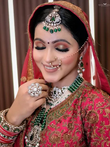 A serene portrait of the bride with her eyes closed, smiling gently. The focus is on her calm demeanor and the beautiful details of her makeup and jewellery.
