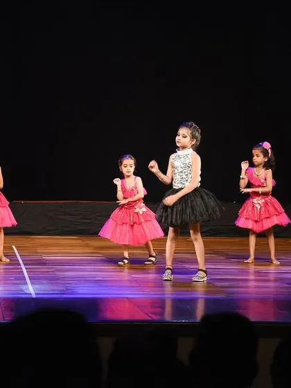 The full group of girls in their pink and black outfits, performing in perfect unison on the Zest stage.