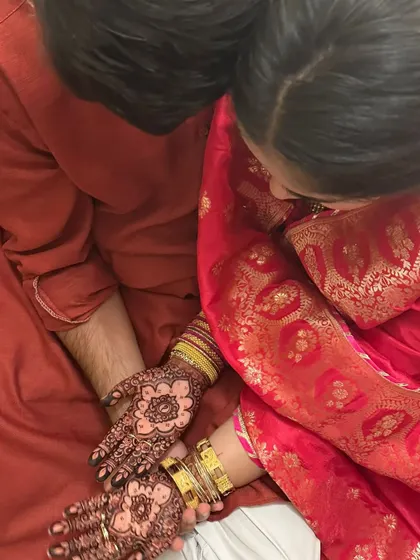 A sweet moment between a couple, with the bride's beautiful henna hands. The stain is a lovely deep color.