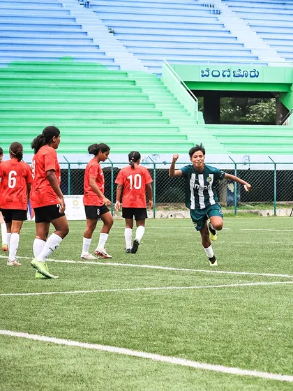 The pure emotion of scoring a goal. A young player celebrates passionately after finding the back of the net for her team.