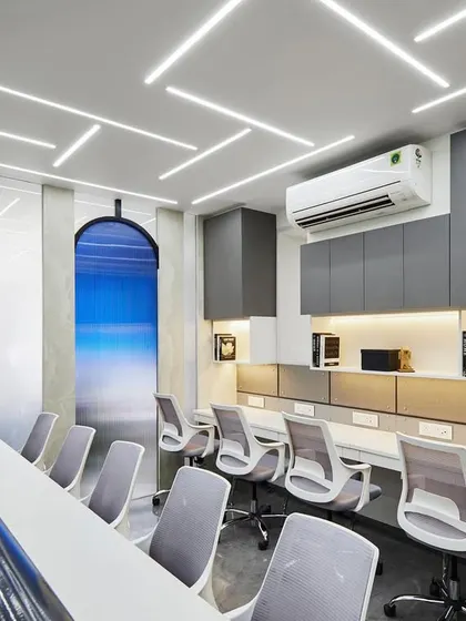 This long workstation is designed for collaboration. Ergonomic chairs provide comfort, while the arched feature wall with a serene blue gradient adds a unique visual element that breaks the monotony of a typical office.