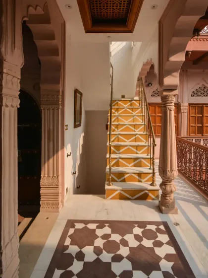 Every detail, from the floor tiles to the staircase, was carefully selected to preserve the haveli's heritage character. The geometric patterns in the flooring add an artistic touch to the space.