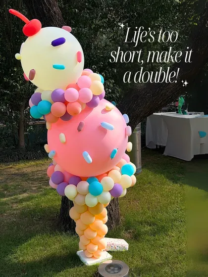 Life's too short, make it a double. A whimsical double-scoop ice cream cone balloon sculpture with colorful sprinkles.