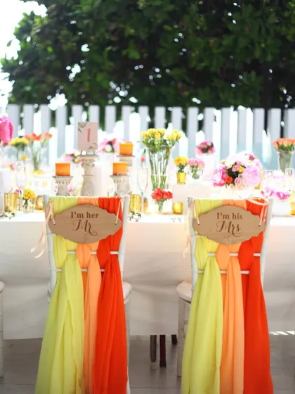 A charming "Mr & Mrs" chair decoration for the couple's table at a bright, colorful daytime event. These playful, personal touches are what make a celebration unique and memorable.