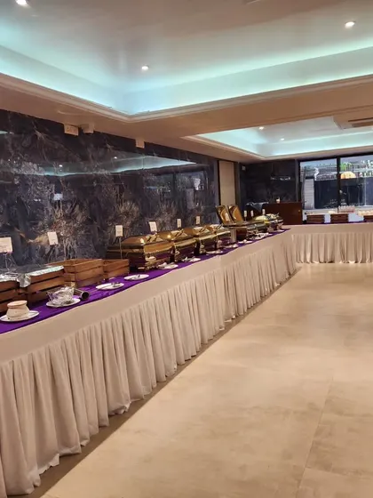 An angled shot of a long buffet line, showcasing the clean and organized arrangement. This setup is perfect for formal banquets and wedding receptions.