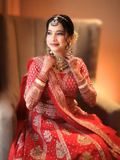 A candid moment of a bride in her red lehenga, looking radiant and happy. My rental service is all about creating these beautiful memories.