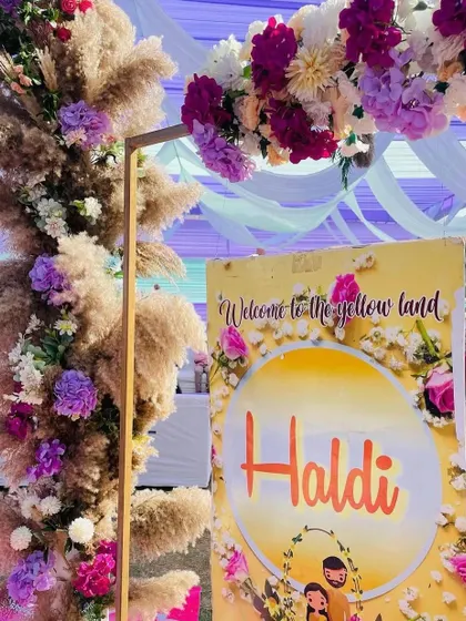 A welcome sign for a Haldi ceremony, framed by pampas grass and flowers. These personalized touches help create a warm and inviting atmosphere.