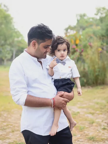 A father and son share a sweet look in this candid outdoor portrait.