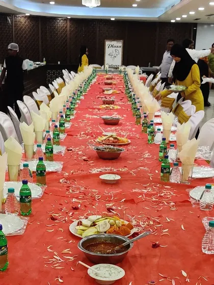 Our team setting up for a 'dawat'. You can see our staff arranging the final touches on the long Dastarkhwan table, ensuring everything is perfect before the guests arrive.