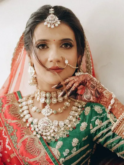 A powerful close-up portrait that showcases the intensity of the eye makeup and the intricate details of the bridal nose ring and jewelry.