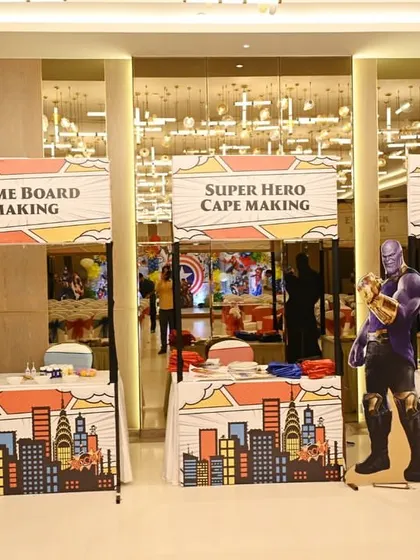 For our superhero party, we set up several DIY stations, including 'Super Hero Cape Making' and 'Eye Mask Making.'