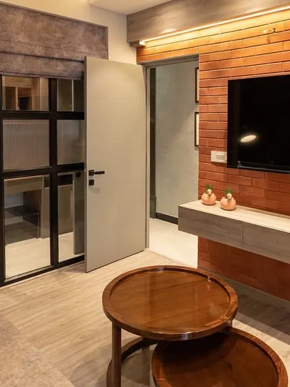 Another angle of the TV lounge, showing the floating media console against the textured brickwork. The warm backlighting behind the console adds ambiance and highlights the rustic texture of the bricks.