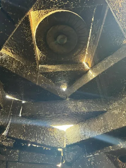 The intricate geometry of the temple's ceiling, with small apertures allowing light to enter. This detail shows how ancient construction techniques can be used to create powerful, timeless architectural effects.