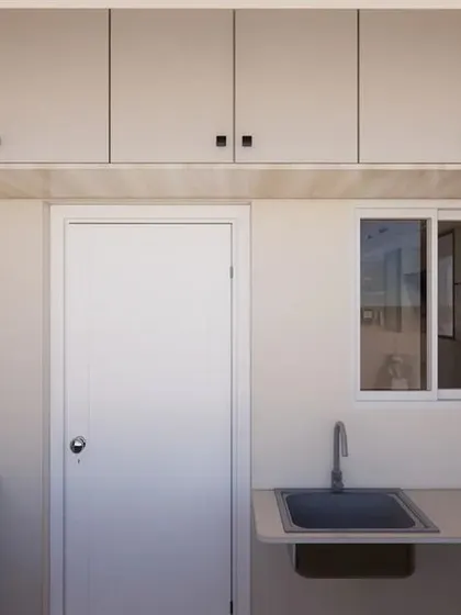 A 3D render of a utility area, designed with ample overhead and base storage to keep laundry and cleaning supplies neatly organized and out of sight.