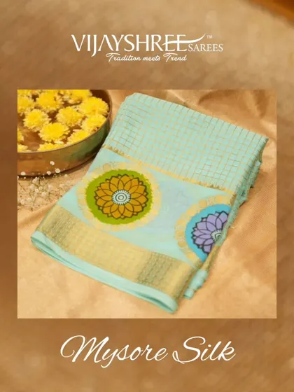 A stunning blue Mysore silk saree with colorful floral motifs, a classic and lightweight option for pujas and small functions.