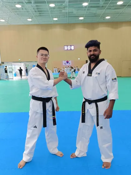 A handshake of sportsmanship with a fellow black belt at the international training program.