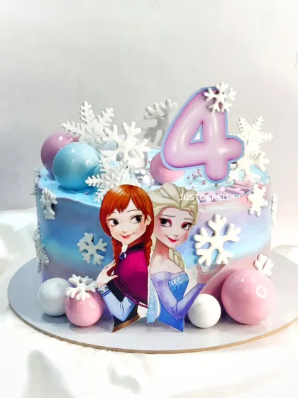 An Elsa and Anna theme cake with a dreamy pastel color palette. The edible snowflakes and chocolate spheres add a touch of winter magic.