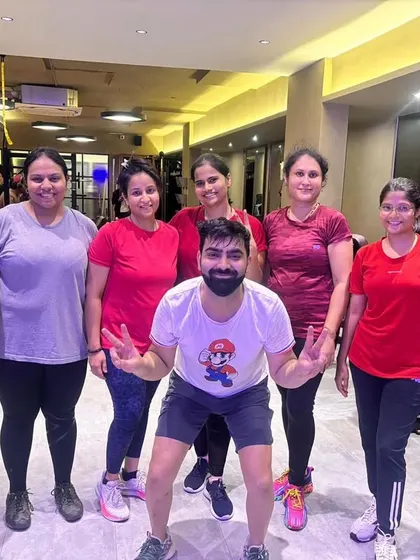 An instructor posing with a group of members after a successful class. Our trainers are dedicated to creating a supportive and motivating environment.