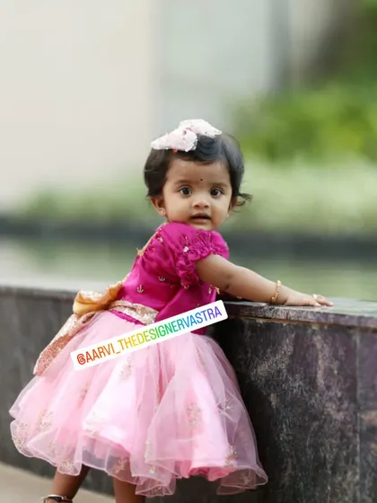 Another adorable shot of the little one in her pink frock. The matching hair bow completes the look.