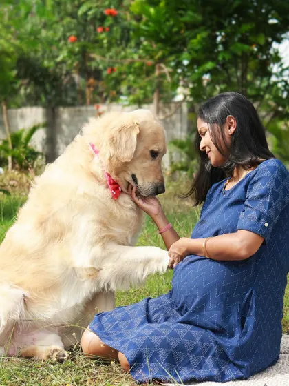 This golden retriever offering his paw is such a touching gesture. During our outdoor maternity session, we focused on capturing these natural interactions that showcase the trust and love between a pet and their owner.
