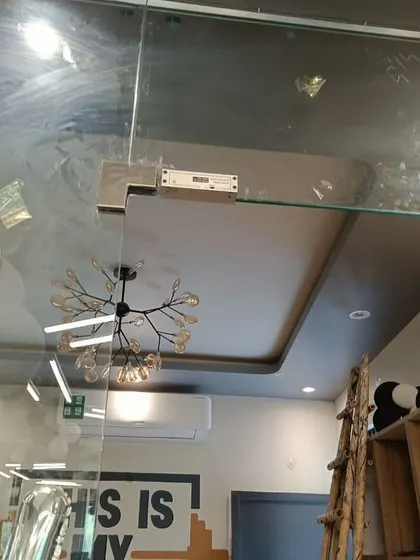 This image shows the EM lock and bracket assembly on the top corner of the gym's glass door, providing a strong and secure locking point.