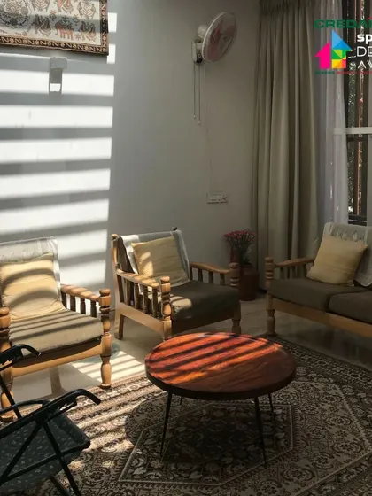 The interior living space is simple and functional, with classic wooden furniture. The patterns of light filtering through the windows become the primary decorative element.