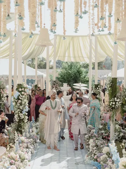 A wide shot of the groom's procession, showing the scale of the floral decor and the beautiful canopy ceiling that framed the entire ceremony space.
