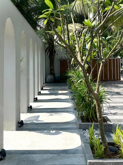 This detail shot of the Tropical Manor's arched walkway shows the interplay of light and shadow. The shadows cast by the arches create a dynamic pattern on the floor, turning a simple walkway into a piece of art that changes throughout the day.